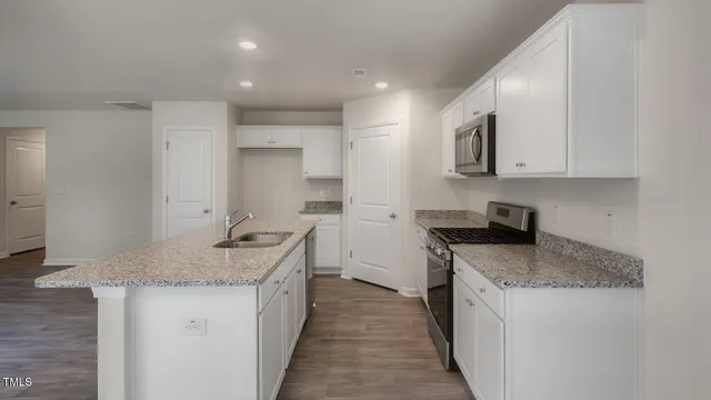 a kitchen with stainless steel appliances granite countertop a sink stove and refrigerator