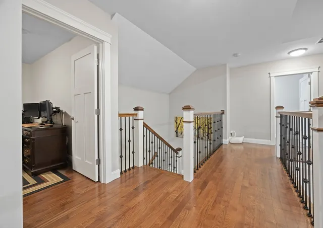 a view of a hallway with wooden floor and stairs