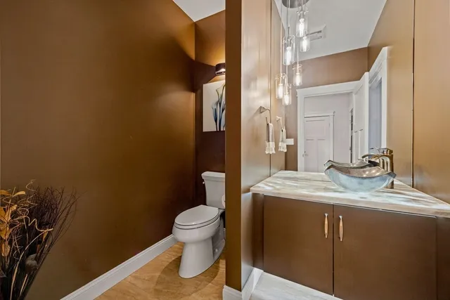 a bathroom with a granite countertop sink toilet and mirror