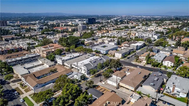 an aerial view of a city with lots of residential buildings and mountain view in back