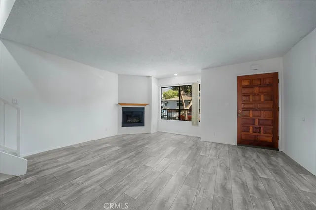 an empty room with fireplace and windows