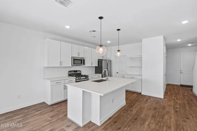 a kitchen with stainless steel appliances granite countertop a sink stove and refrigerator