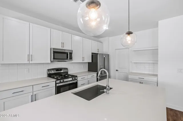 a kitchen with stainless steel appliances white cabinets and a stove