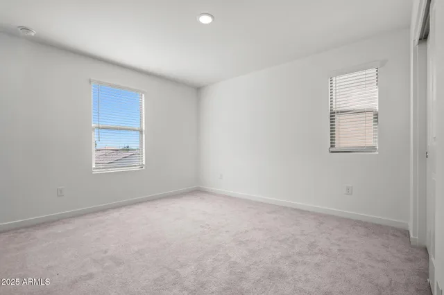 an empty room with windows and closet