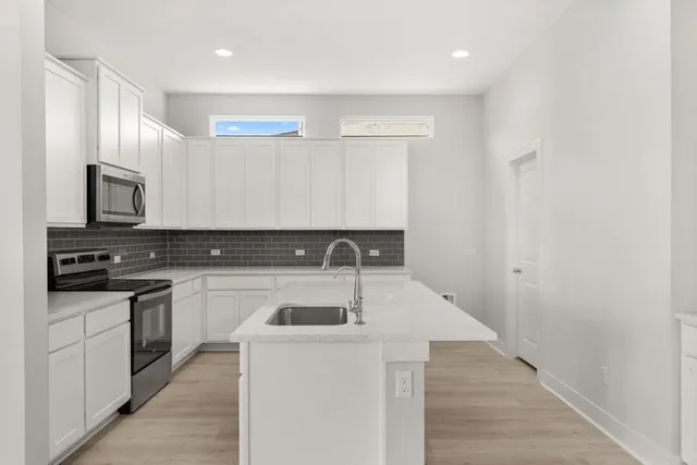 a kitchen with a sink and white cabinets