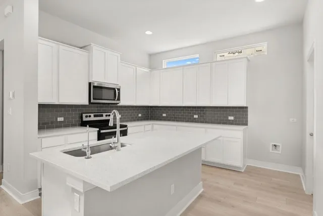 a kitchen with a sink a microwave and cabinets