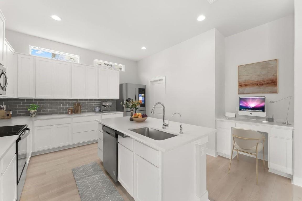 2200 Grenache Drive, Unit 105 Round Rock, TX 78664 - Photo 4 of 15 a kitchen that has a sink and a stove in it