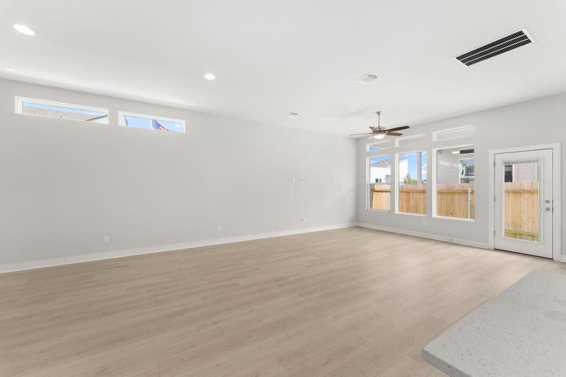 2200 Grenache Drive, Unit 105 Round Rock, TX 78664 - Photo 7 of 15 an empty room with wooden floor and windows