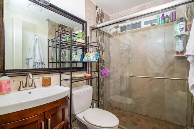 a bathroom with a sink a toilet and shower