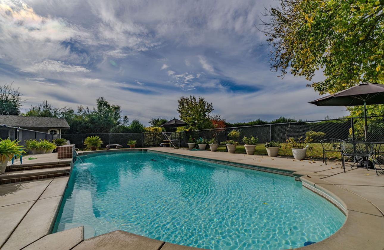 22140 North Clements Clements, CA 95227 - Photo 34 of 88 a view of a swimming pool with lawn chairs under an umbrella
