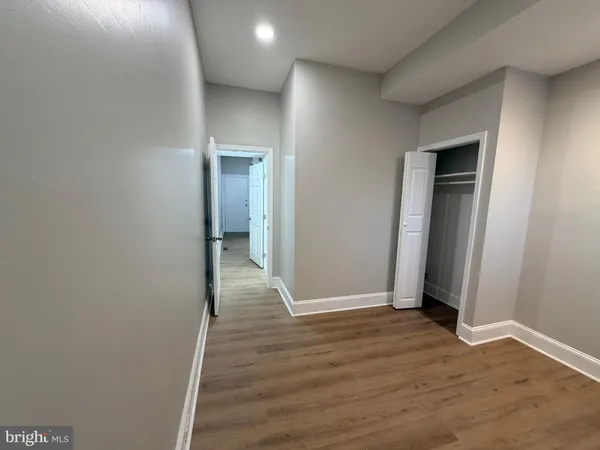 an empty room with wooden floor and closet