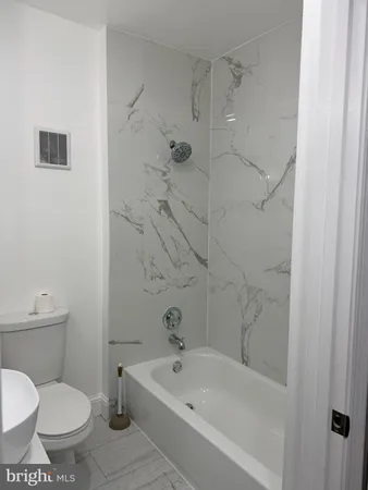 a bath room with a toilet sink and shower