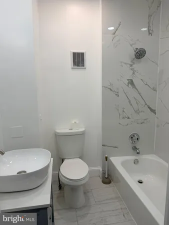a bathroom with a toilet sink and shower