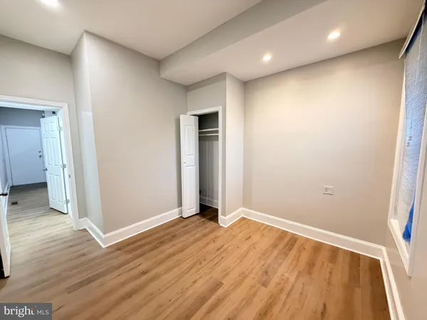 an empty room with wooden floor and entrance
