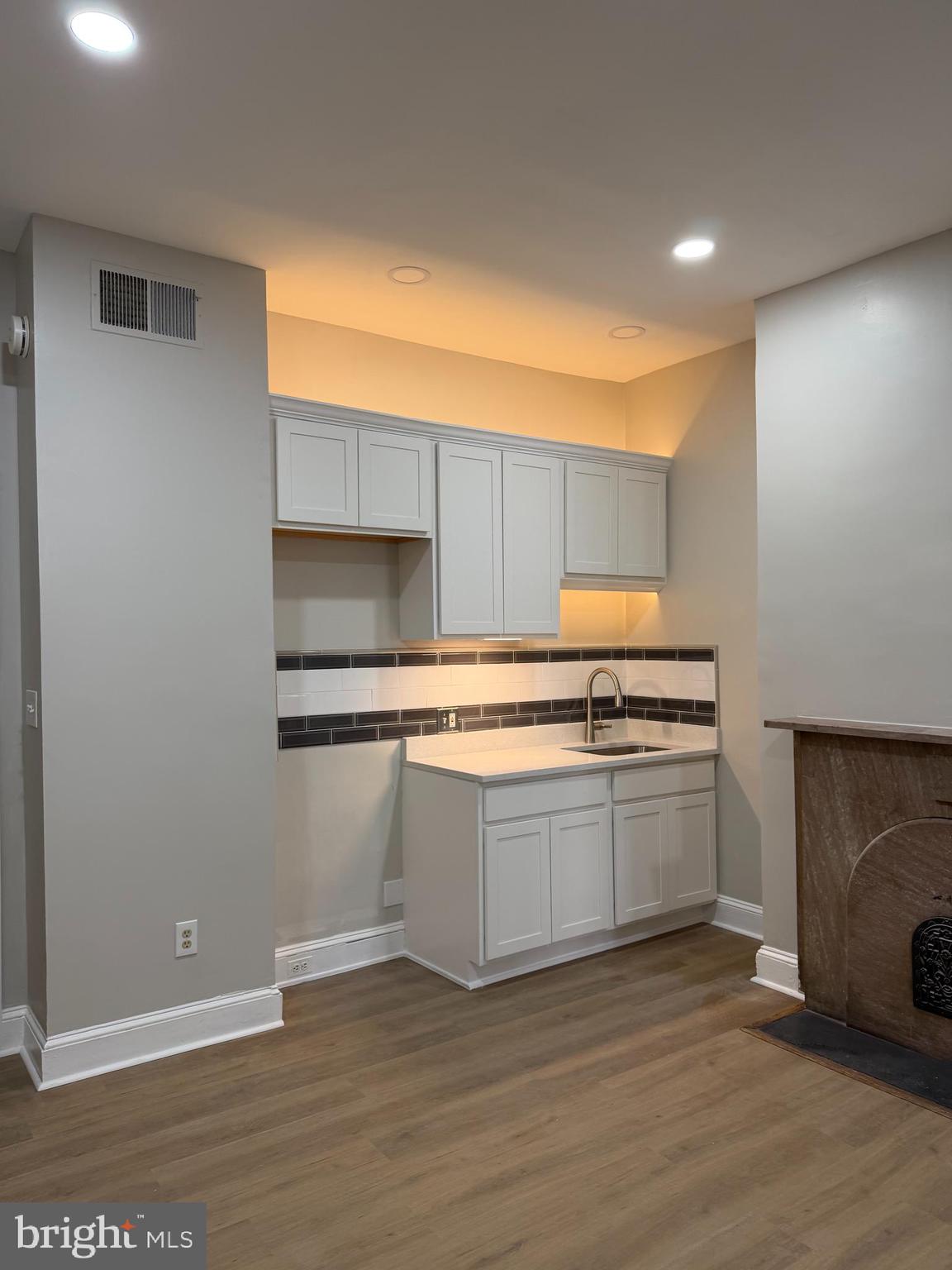 2439 Maryland Avenue, Unit B Baltimore, MD 21218 - Photo 2 of 3 a kitchen with granite countertop a stove and a wooden cabinets