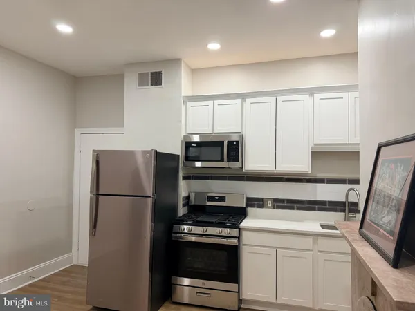 a kitchen with a refrigerator stove and microwave