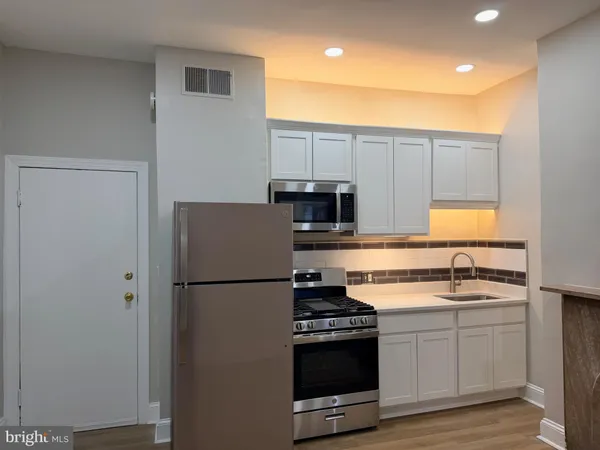 a kitchen with a sink appliances and cabinets