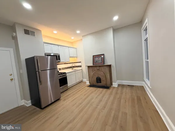 a kitchen with a refrigerator sink and cabinets