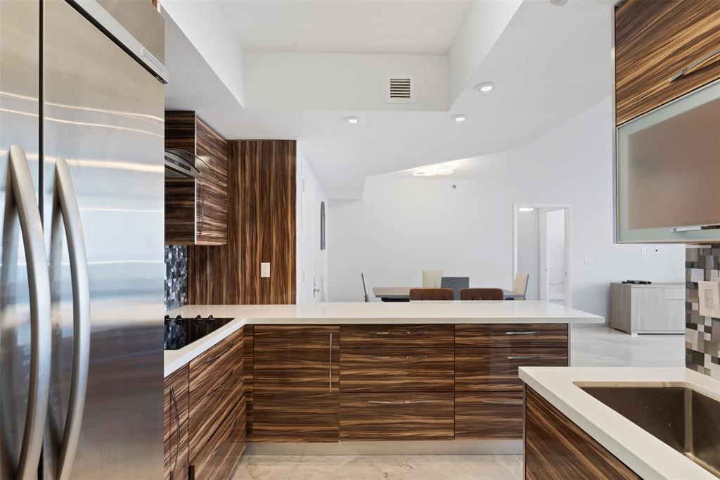 18911 Collins Avenue, Unit 3003 Sunny Isles Beach, FL 33160 - Photo 14 of 53 a kitchen with stainless steel appliances granite countertop a sink and a refrigerator