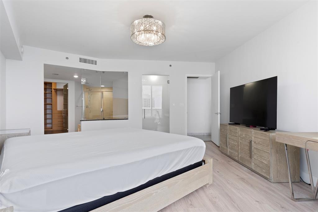 18911 Collins Avenue, Unit 3003 Sunny Isles Beach, FL 33160 - Photo 17 of 53 a bedroom with a bed and a flat tv screen on wall