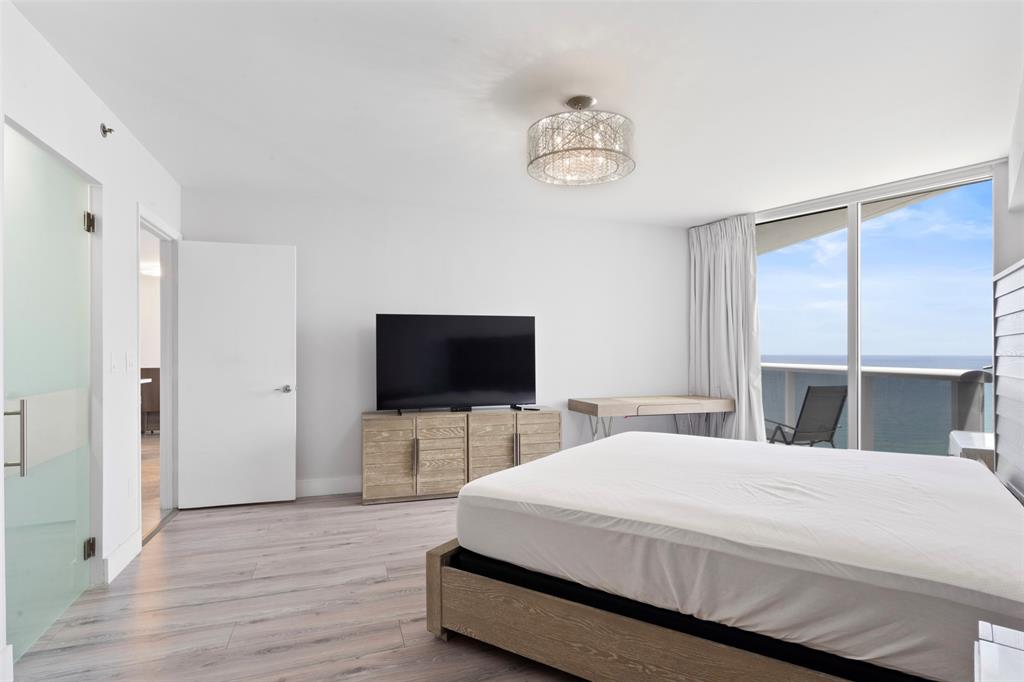 18911 Collins Avenue, Unit 3003 Sunny Isles Beach, FL 33160 - Photo 19 of 53 a bedroom with a bed and a flat screen tv