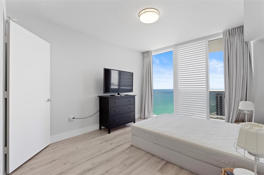 18911 Collins Avenue, Unit 3003 Sunny Isles Beach, FL 33160 - Photo 33 of 53 a bedroom with a bed and a flat screen tv