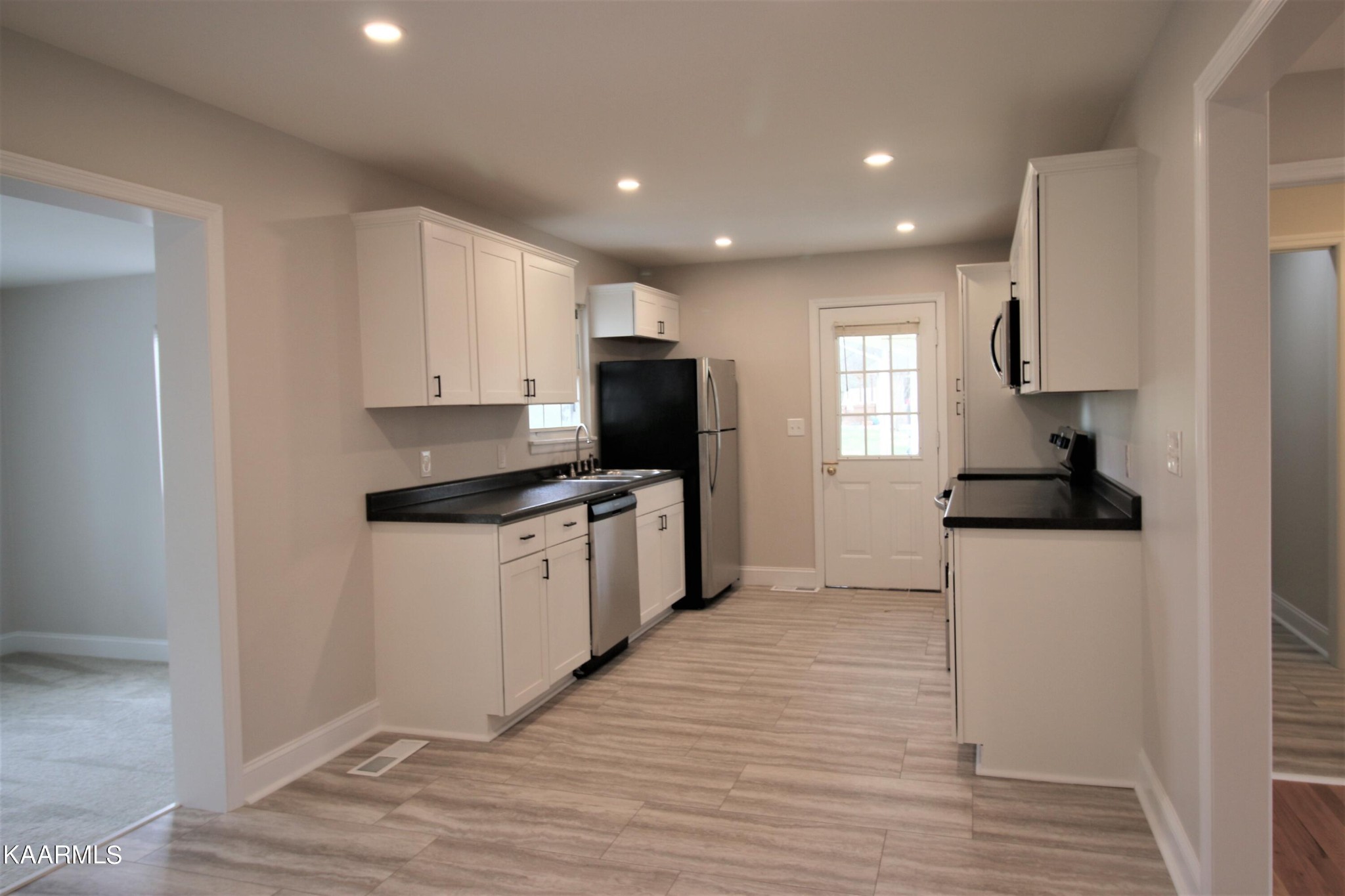 124 West Lincoln Road Oak Ridge, TN 37830 - Photo 21 of 27 a kitchen with granite countertop white cabinets and stainless steel appliances
