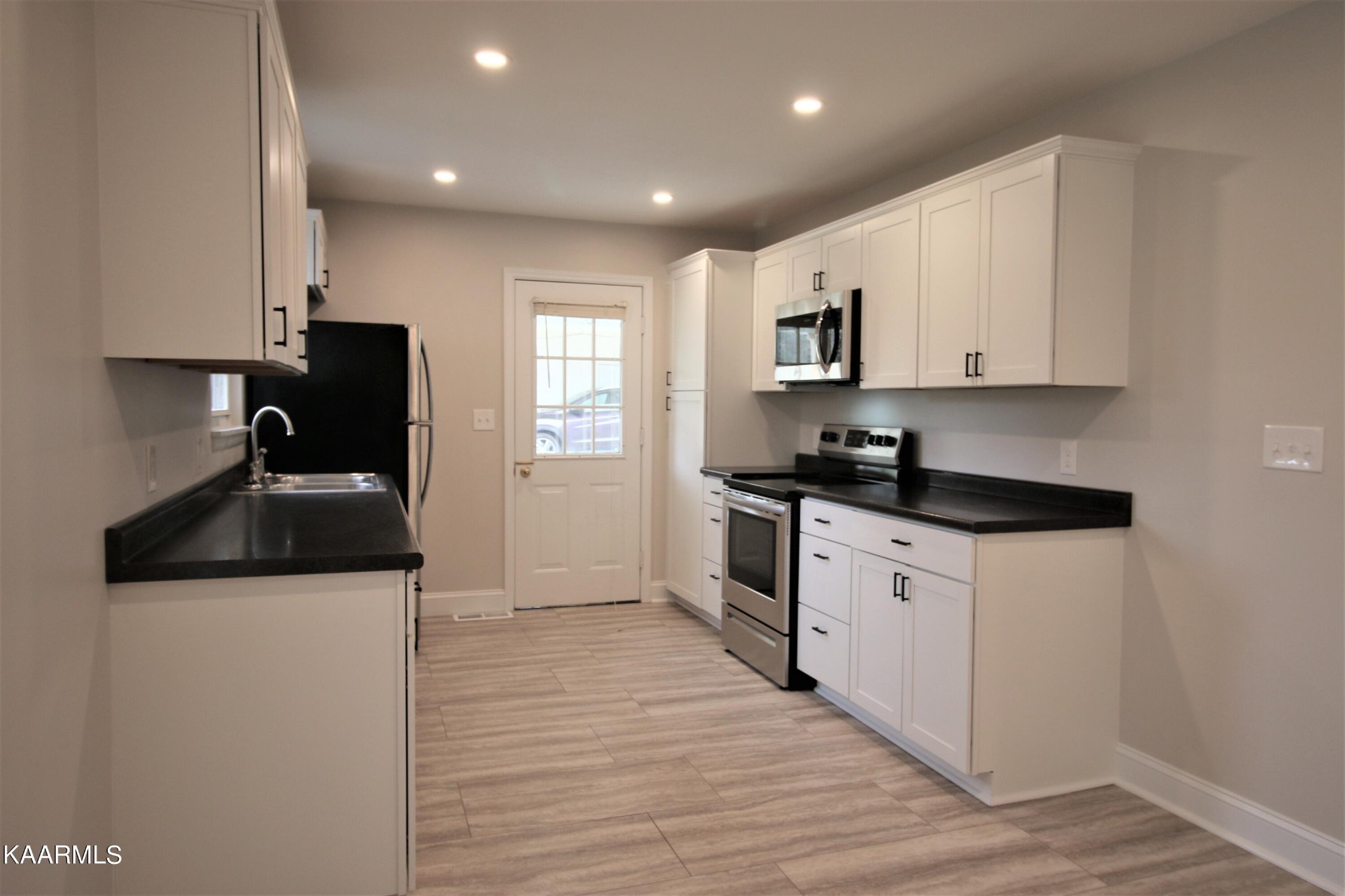 124 West Lincoln Road Oak Ridge, TN 37830 - Photo 22 of 27 a kitchen with granite countertop a sink and a stove top oven