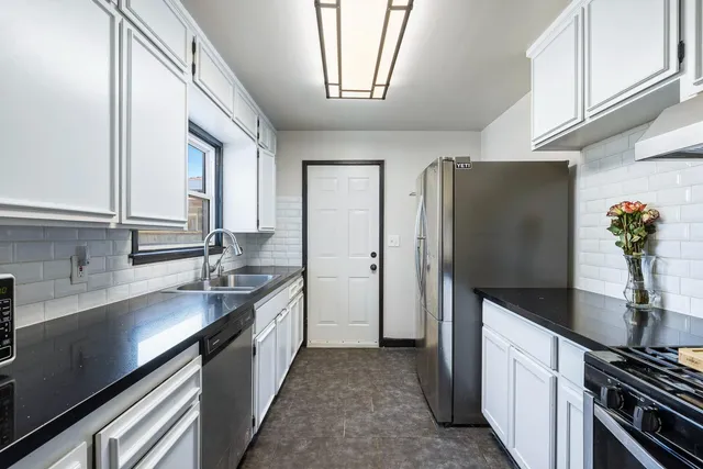 a kitchen with stainless steel appliances a sink stove and refrigerator