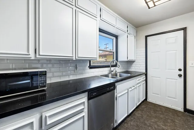 a kitchen with stainless steel appliances granite countertop a sink and cabinets