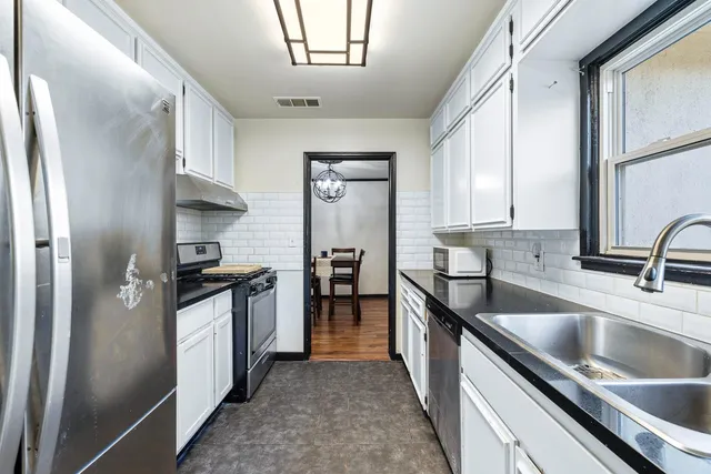 a kitchen with granite countertop a sink stove and refrigerator