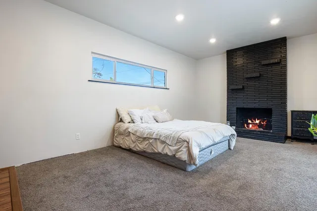 a spacious bedroom with a bed and a fireplace