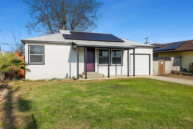 a backyard of a house with table and chairs