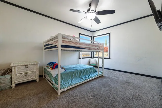 a spacious bedroom with a bed and a ceiling fan