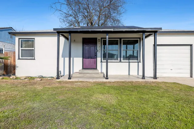 a view of a house with a yard and garage