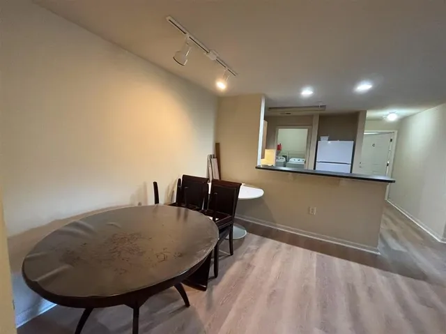 a living room with couches and kitchen view with wooden floor