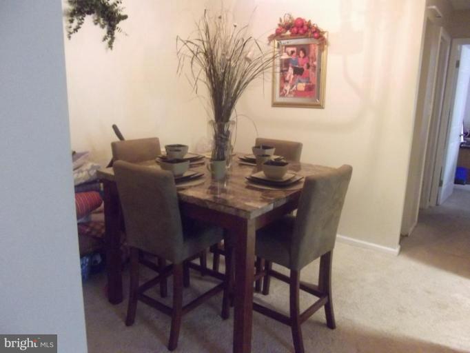 8013 Mandan Road, Unit 304 Greenbelt, MD 20770 - Photo 10 of 12 a view of a dining room with furniture and a potted plant