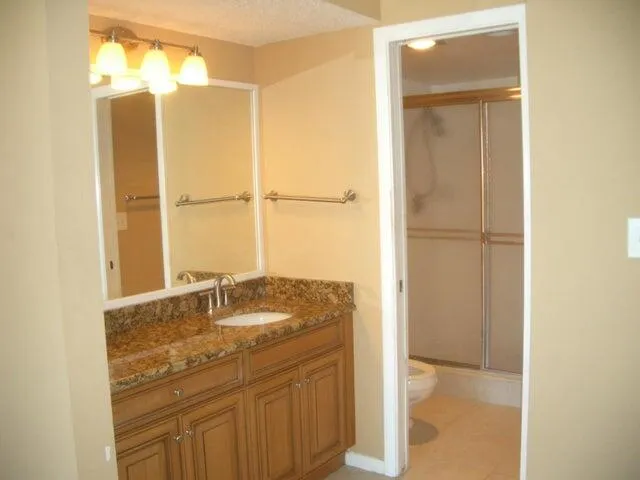 a bathroom with a granite countertop sink and a mirror