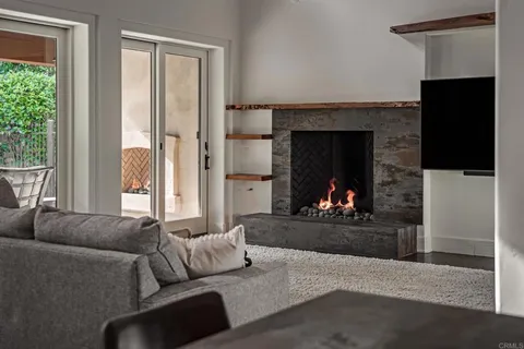 a living room with furniture a fireplace and a large window