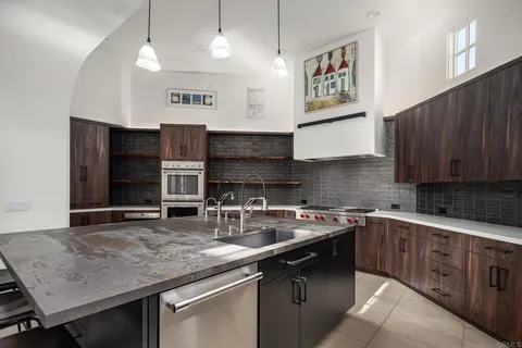a kitchen with stainless steel appliances granite countertop a sink stove and cabinets