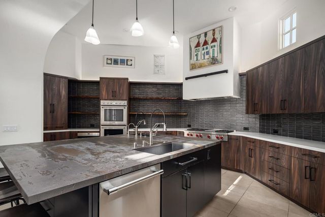 a kitchen with stainless steel appliances granite countertop a sink stove and cabinets