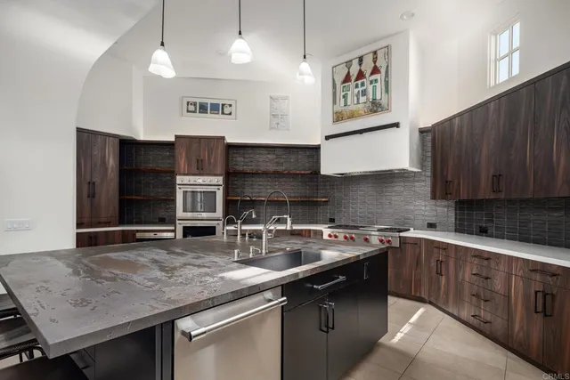 a kitchen with stainless steel appliances granite countertop a sink stove and cabinets