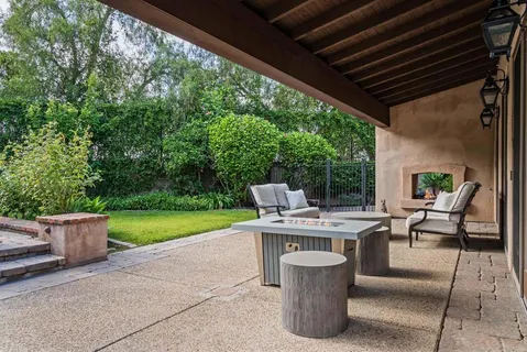 a view of a patio with a table and chairs and potted plants