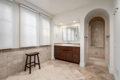 a spacious bathroom with a granite countertop sink mirror and a bathtub