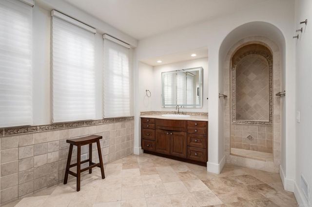a spacious bathroom with a granite countertop sink mirror and a bathtub