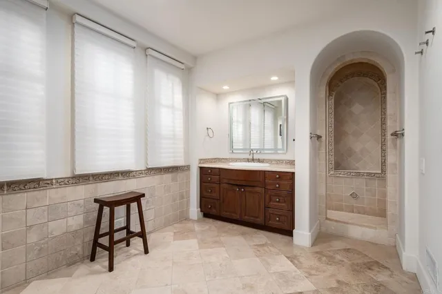 a spacious bathroom with a granite countertop sink mirror and a bathtub