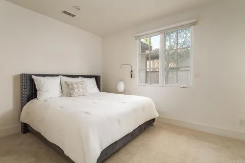 a large bed sitting in a bedroom next to a window