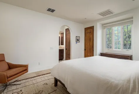 a bedroom with a bed couch and a window