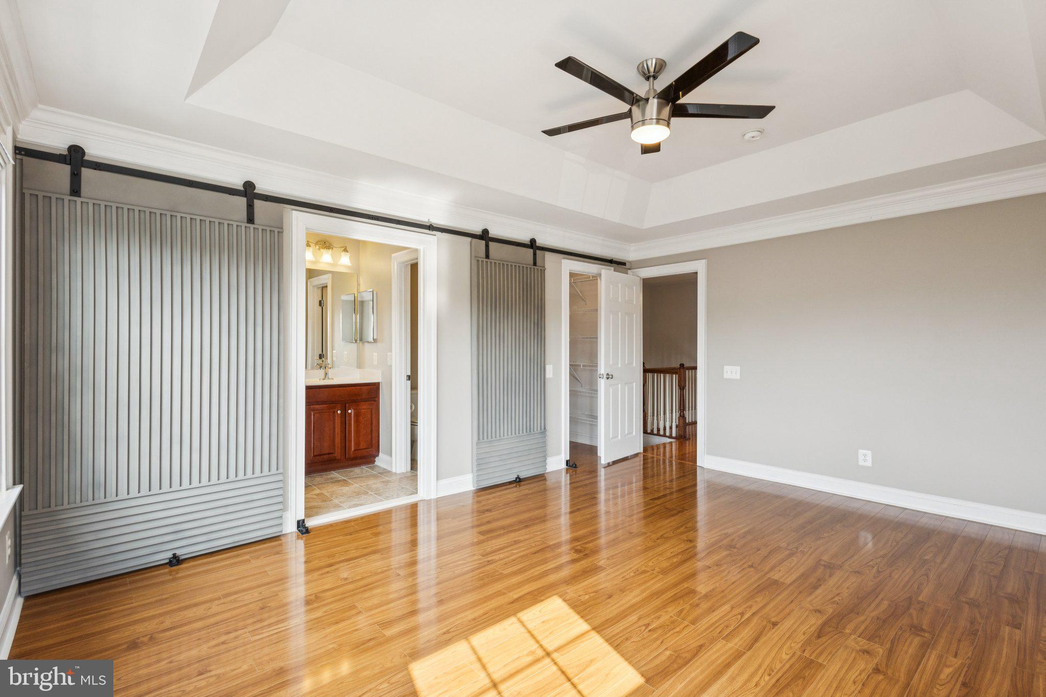 42761 Hay Road Ashburn, VA 20147 - Photo 12 of 46 an empty room with wooden floor and a ceiling fan
