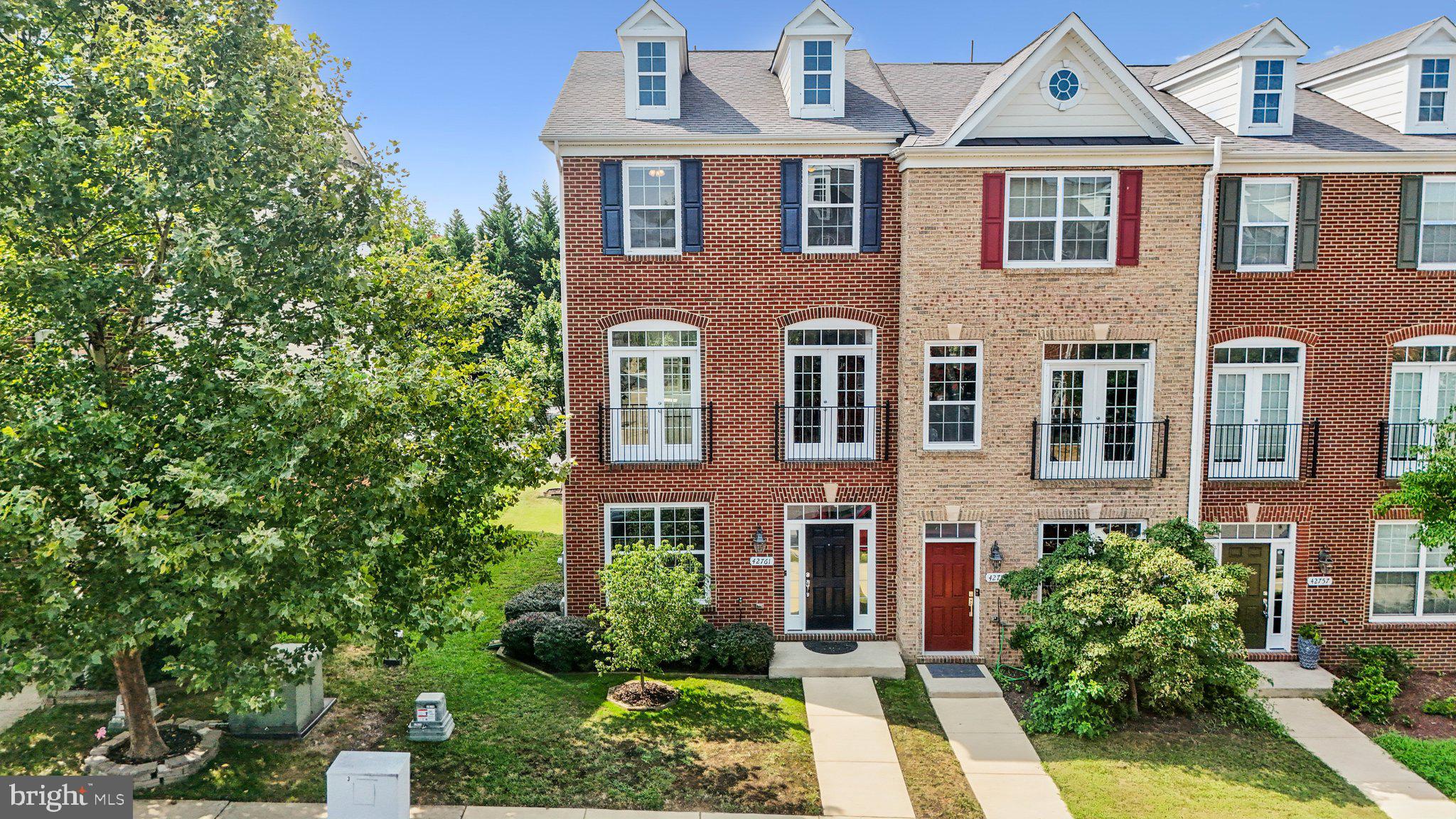 42761 Hay Road Ashburn, VA 20147 - Photo 2 of 46 front view of a brick house with a small yard and large trees
